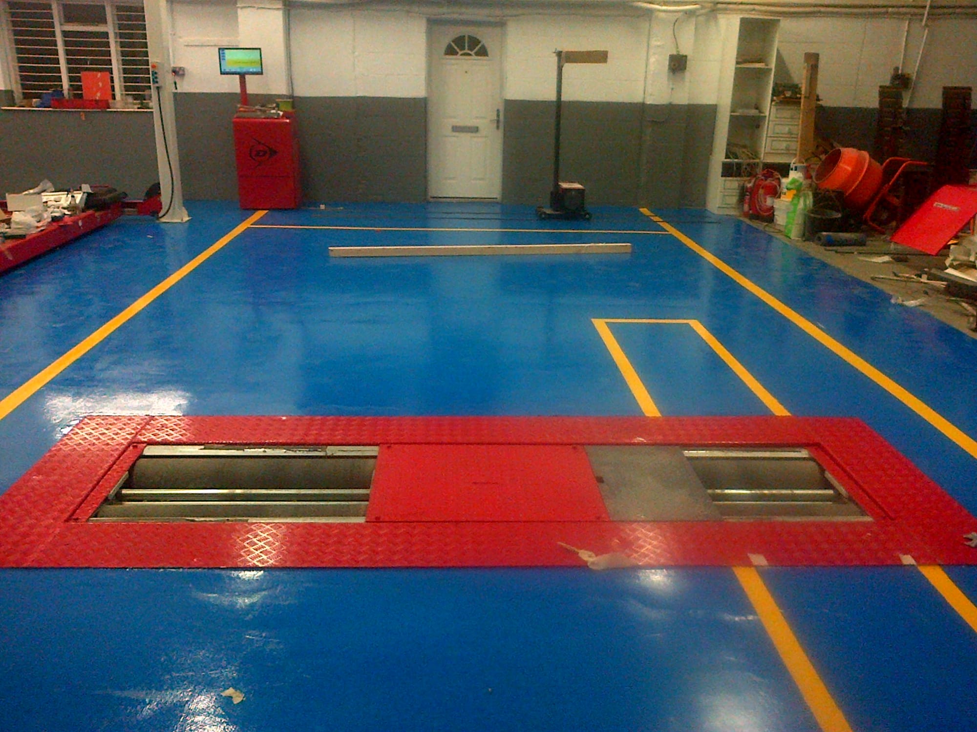 Roller brake tester testing area, operation control cabinet to rear.