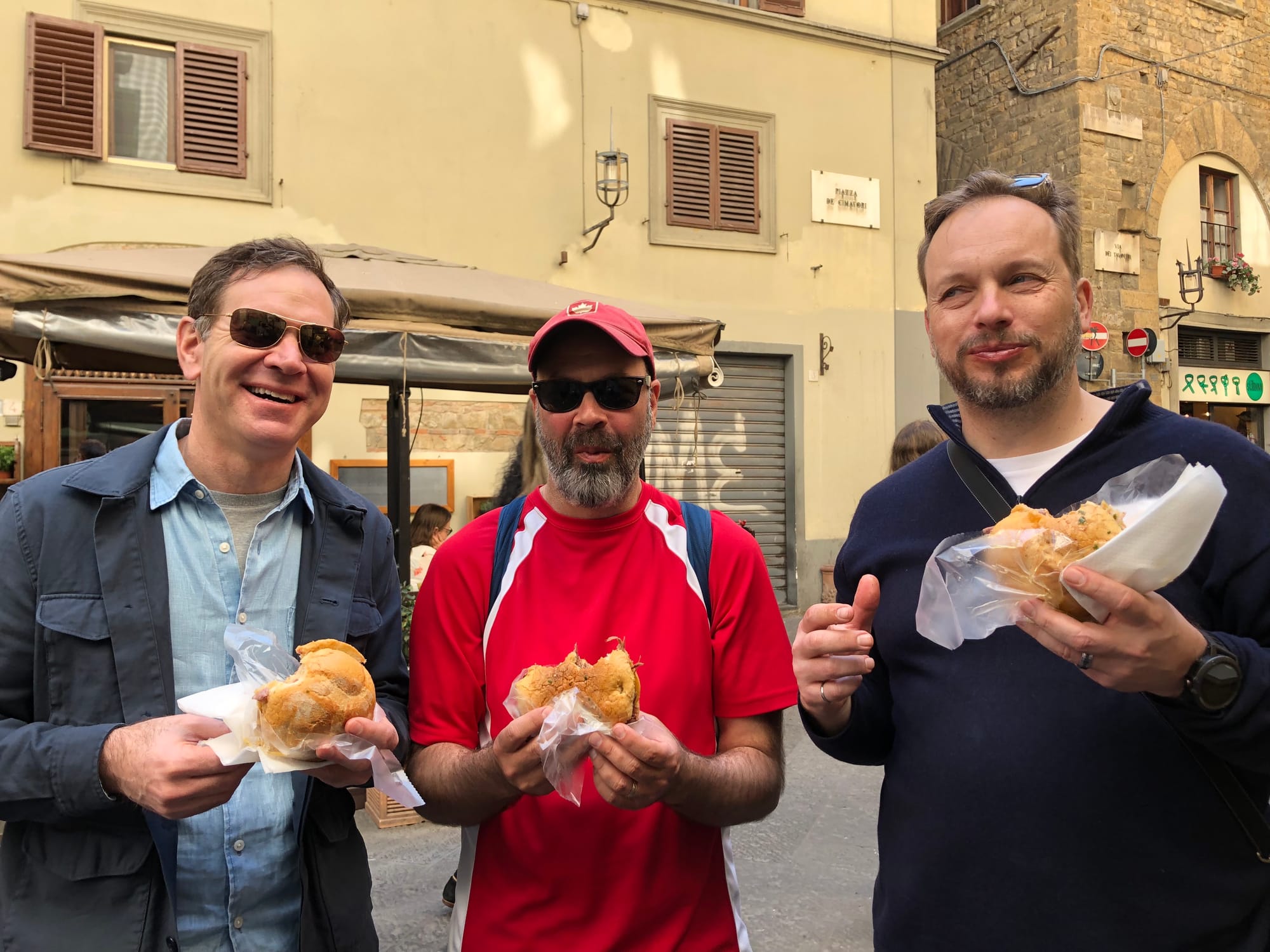 Three cool dudes eating weird street food.