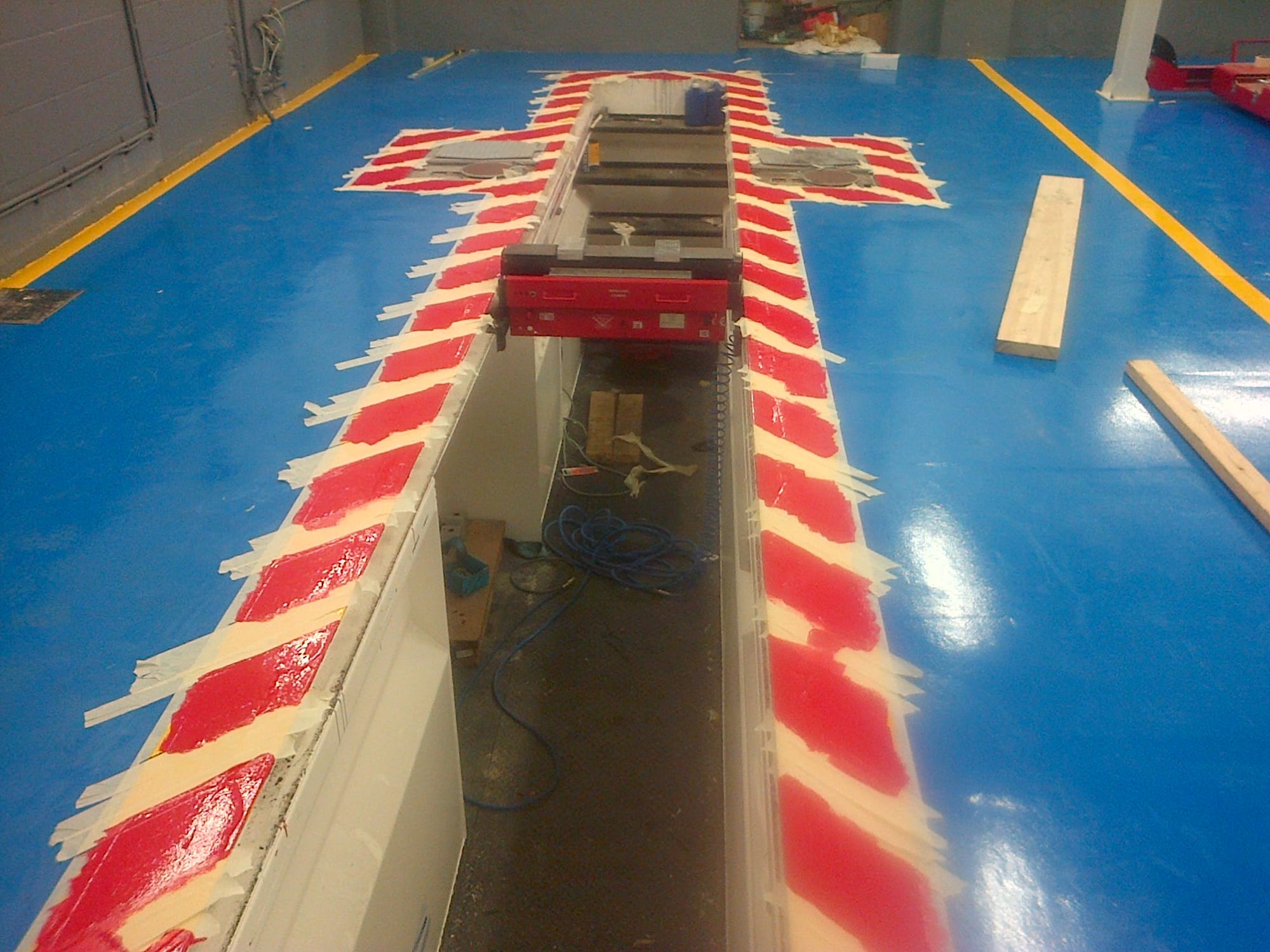 Concrete poured around pit, floor painted, safety markings being applied.