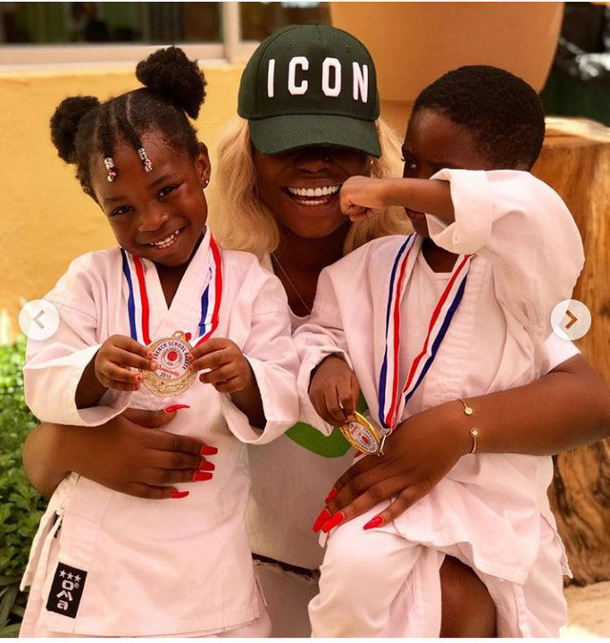 Davido's first daughter, Imade and Tiwa Savage's son, Jamal poses together as they shows off their karate medals.