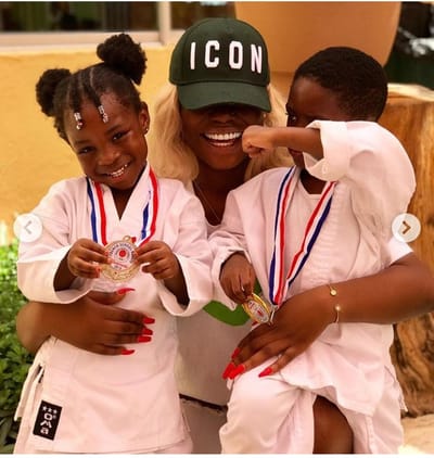 Davido's first daughter, Imade and Tiwa Savage's son, Jamal poses together as they shows off their karate medals.