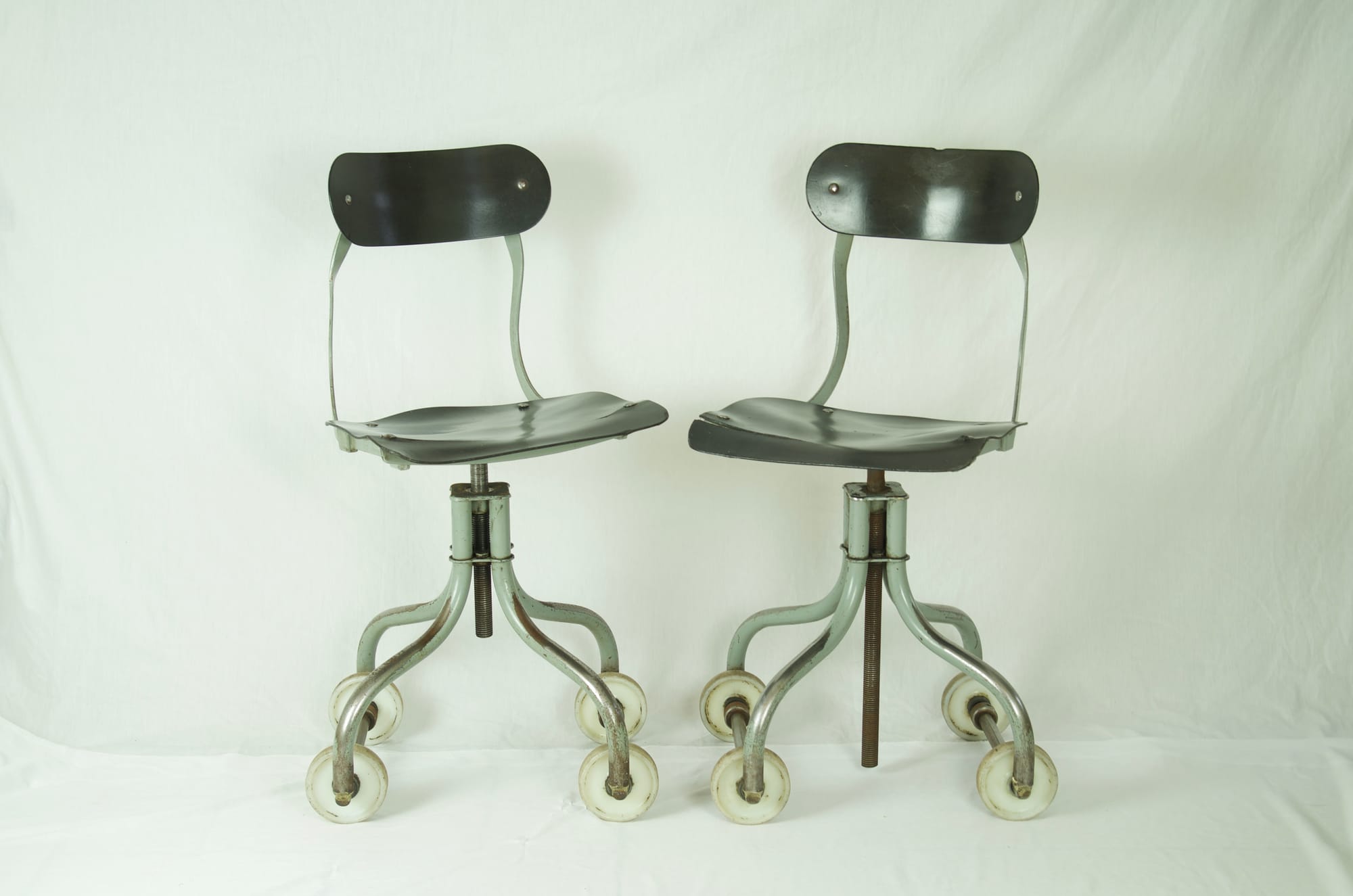 A Pair of vintage Industrial factory chairs On Rollers.