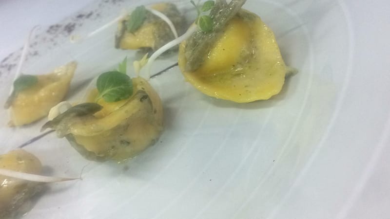 Raviolo del plin ripieno di baccalà mantecato con crema di carciofi e riduzione di strega