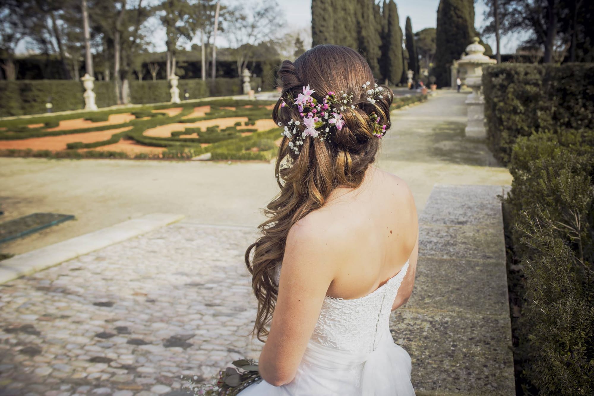 Coiffure mariage en cascade de boucles wavy et fleurs fraîches