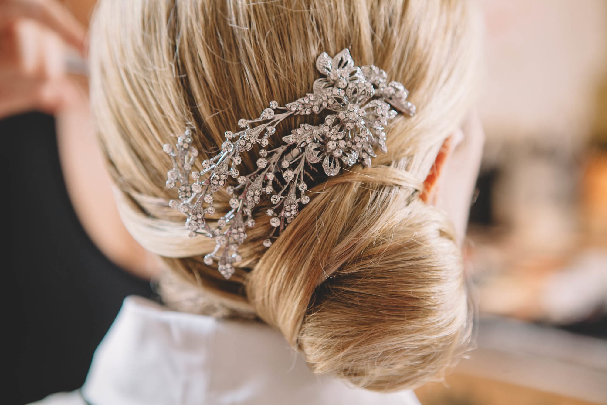 Chignon bas mariage de coté, orné d'un bijoux pour cheveux.