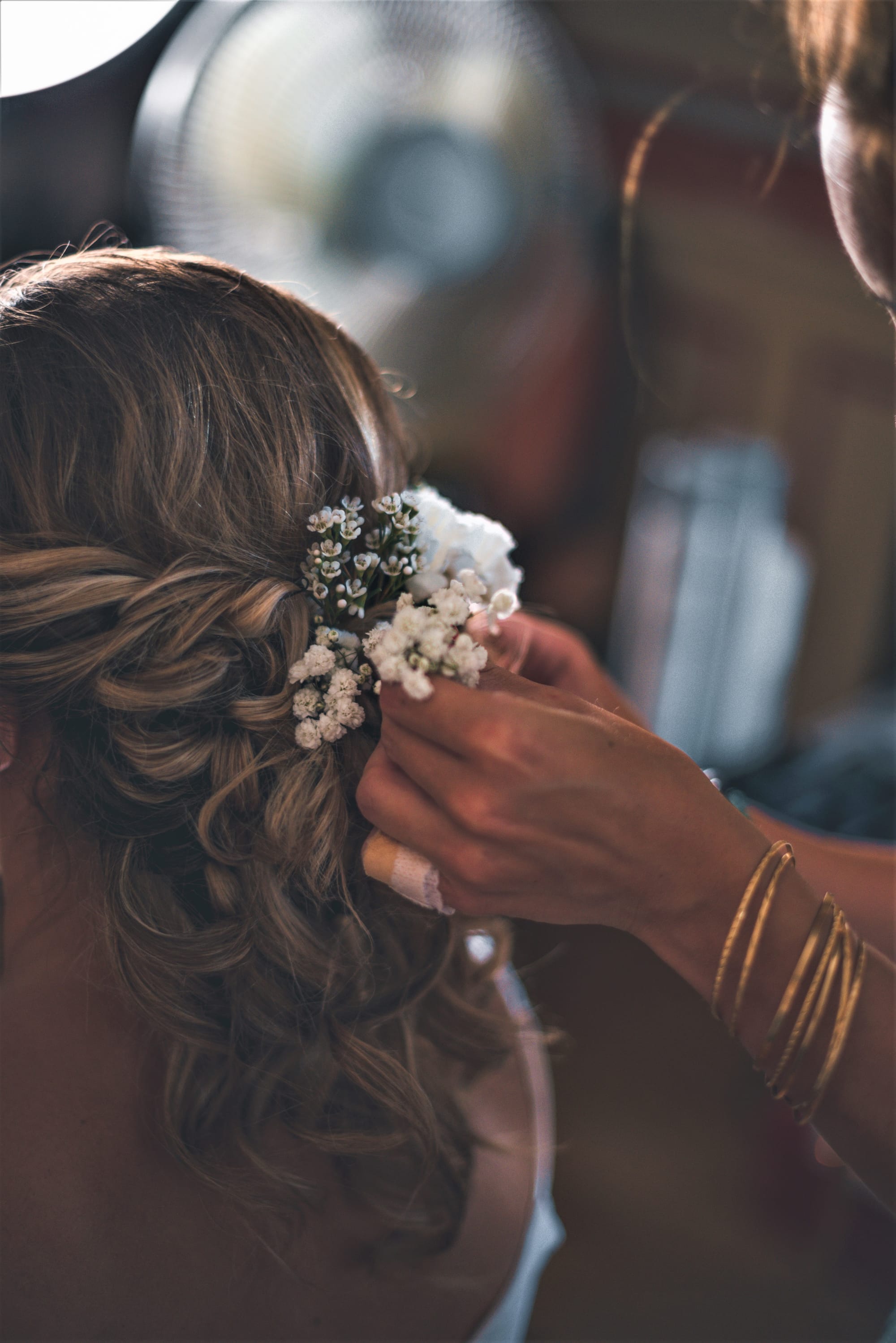 Coiffure mariage chignon bas lâché et fleurs romantique