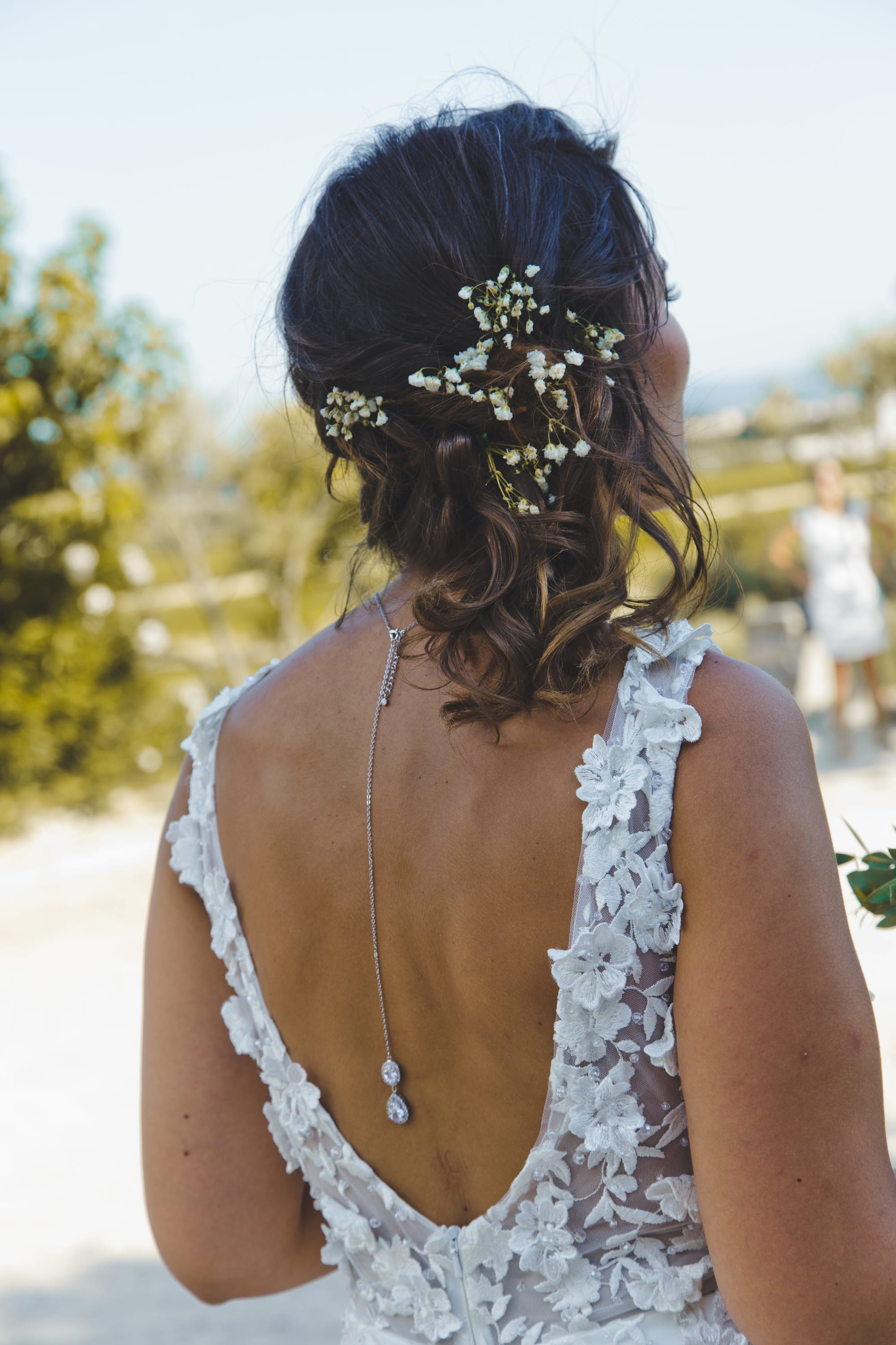 Coiffure de mariée en chinon bas sur le coté avec cascade de boucle et gypsophile