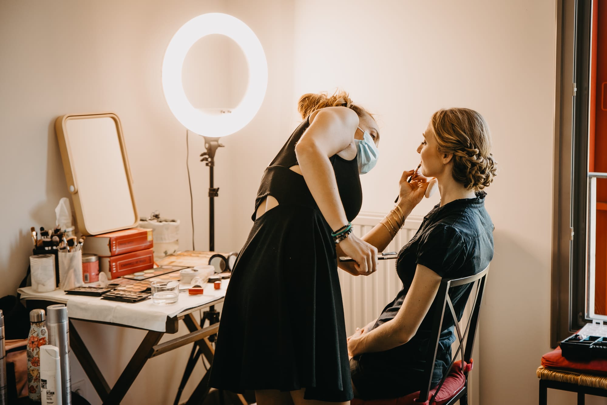 Anais en train de maquiller une mariée avec un chignon princesse.