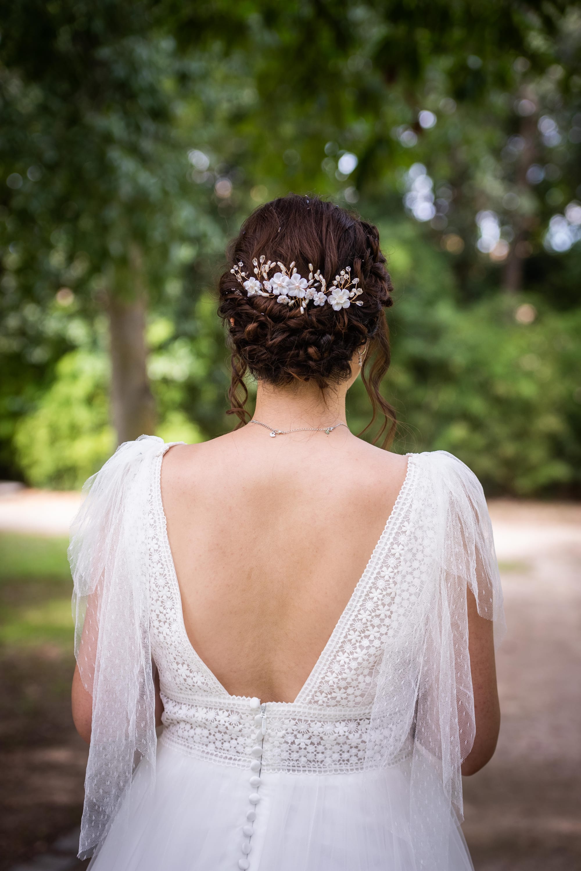 Chignon de mariée bas effet flou avec fleurs romantiques