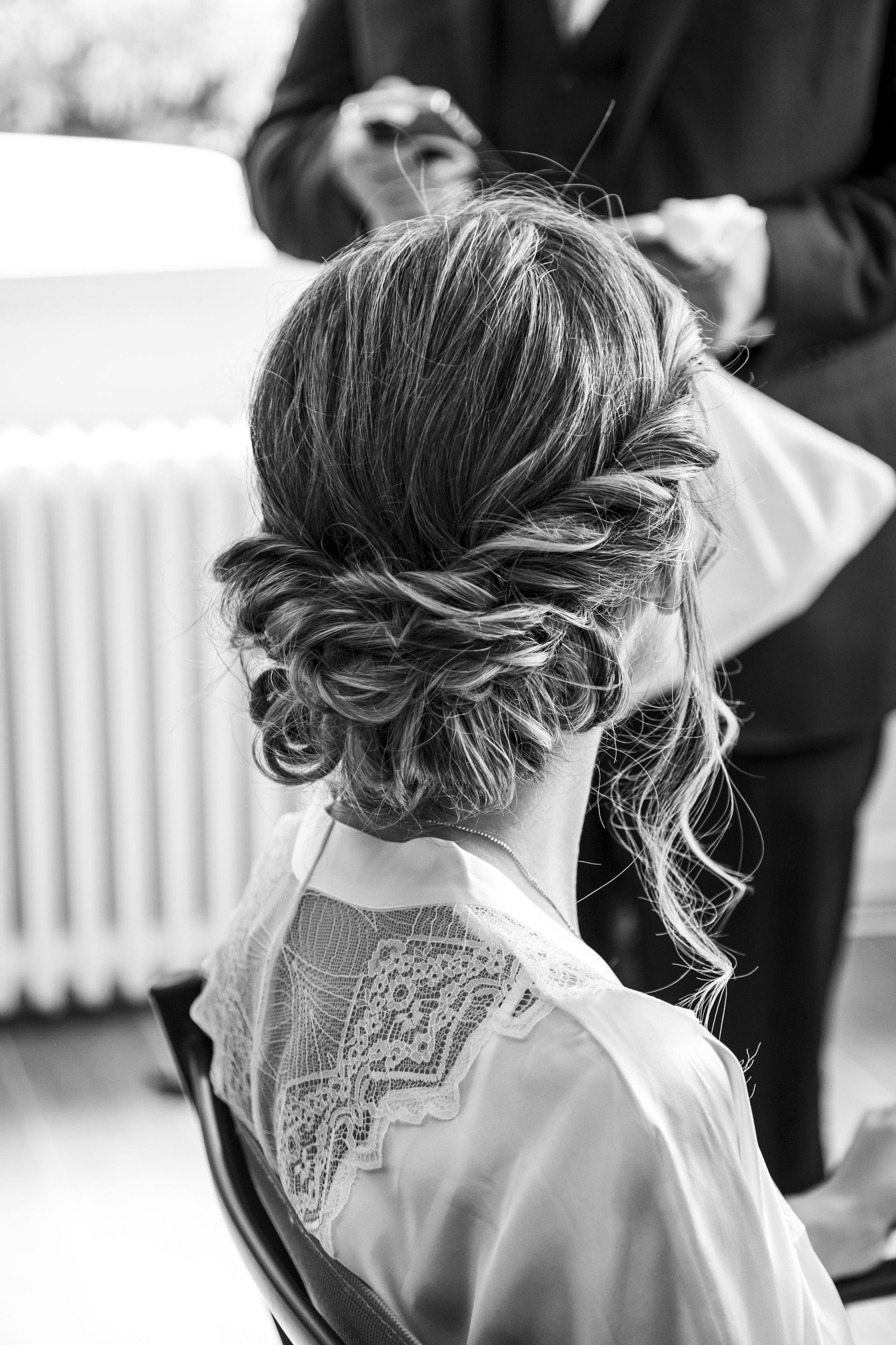 Coiffure de mariée princesse avec un chignon bas tressé et ondulé