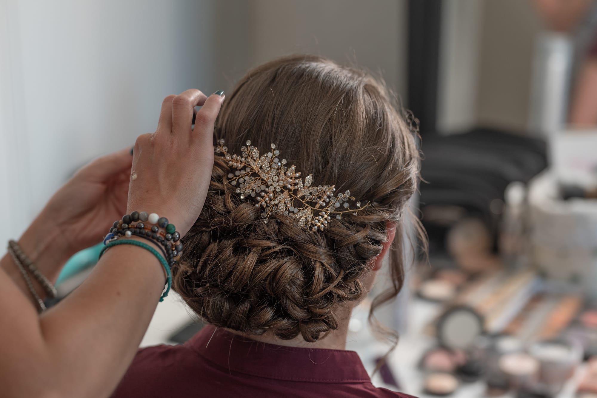 Coiffure de mariage avec chignon bas et ondulé, sublimé par des bijoux de cheveux