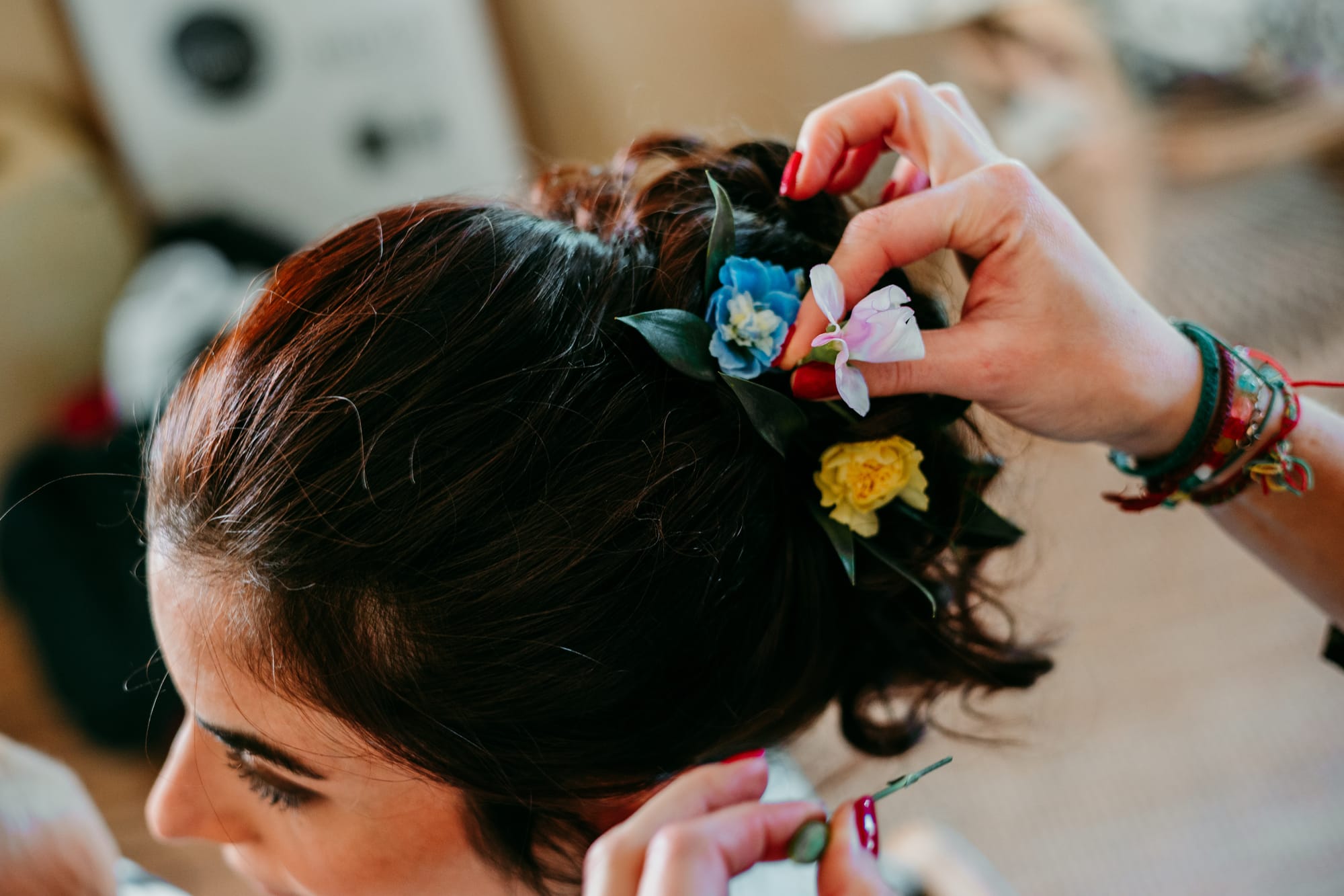 Chignon flou de mariée avec fleurs naturelles colorées