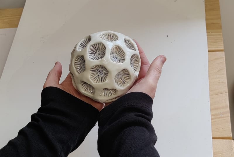 Porcelain. Hand built and glazed with body stains and clear glaze. Approximately 15cm in diameter. 