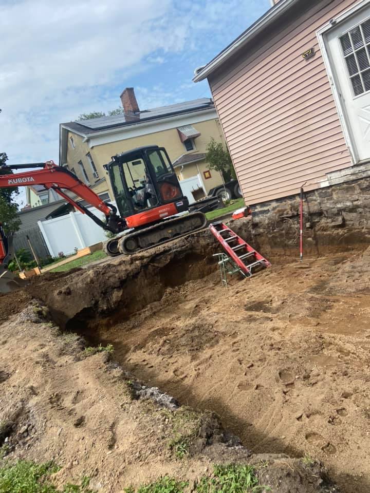 Excavation, footings, walls & waterproofing of a poured concrete foundation.