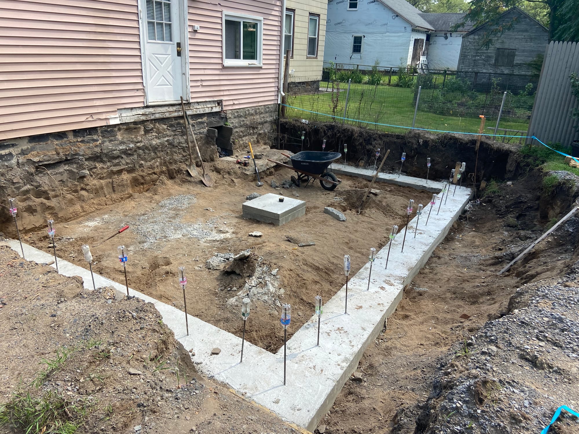 Excavation, footings, walls & waterproofing of a poured concrete foundation.