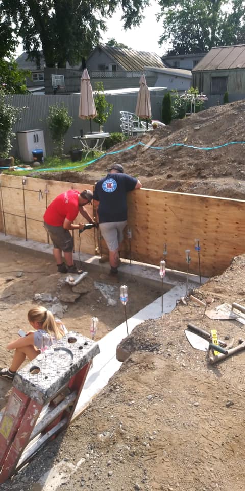Excavation, footings, walls & waterproofing of a poured concrete foundation.