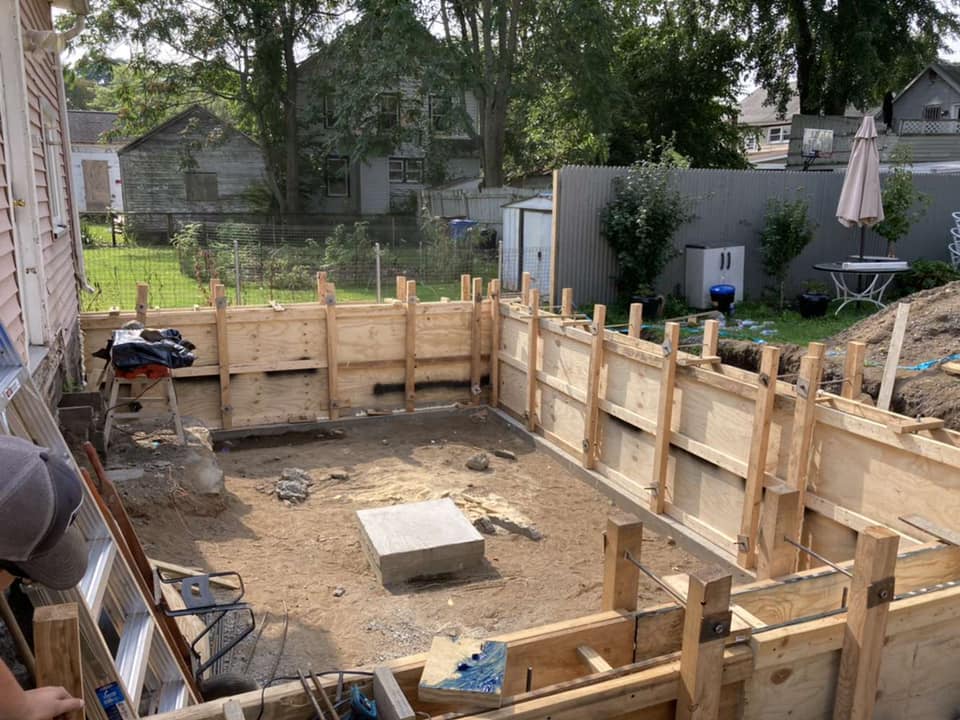 Excavation, footings, walls & waterproofing of a poured concrete foundation.