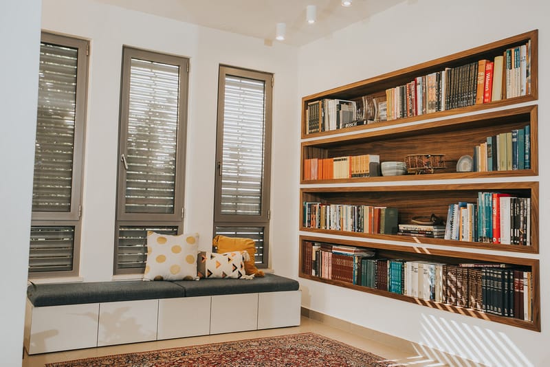 מדפי ספרים שקועים מובנים ומושב קריאה מרופד