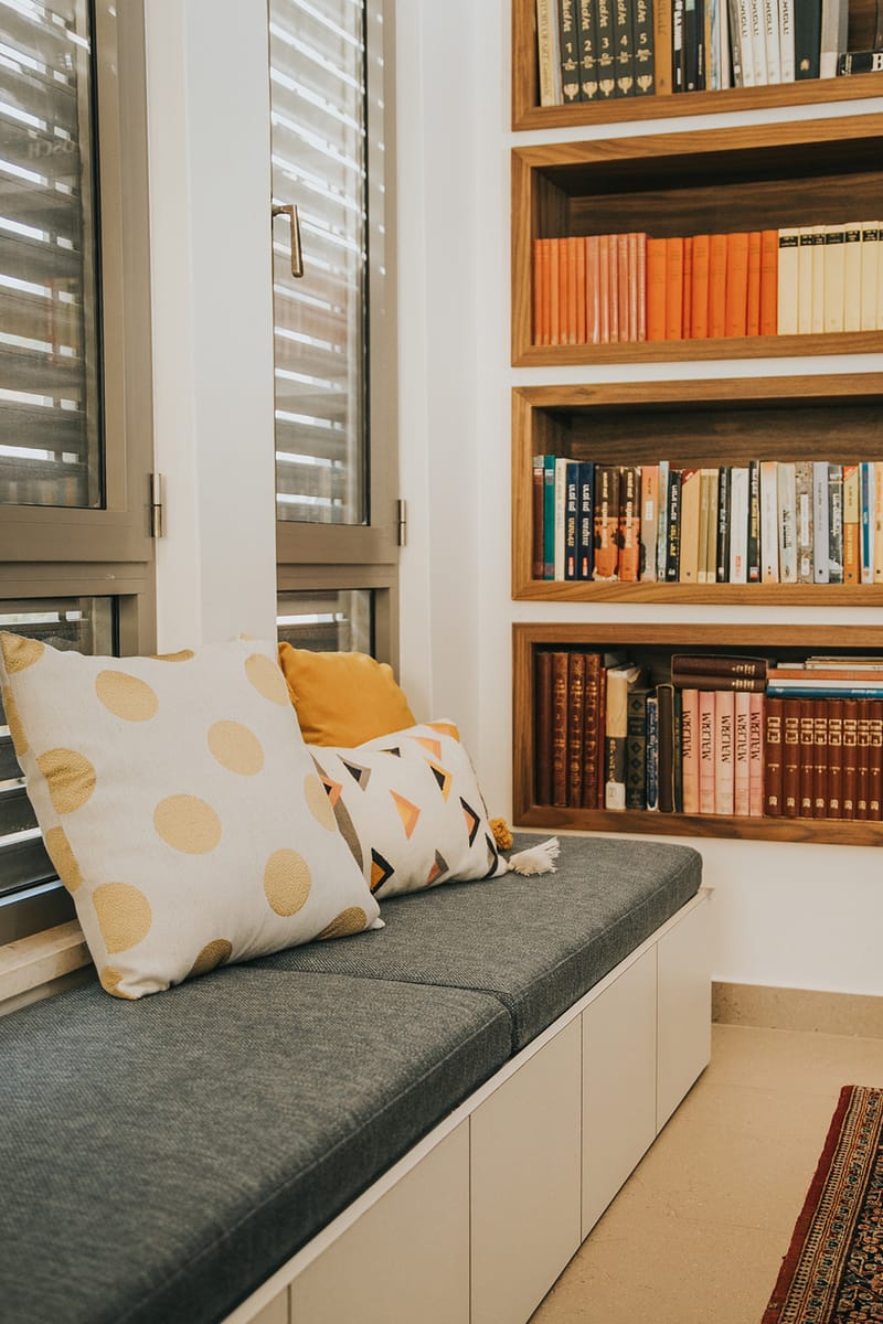 מדפי ספרים שקועים מובנים ומושב קריאה מרופד