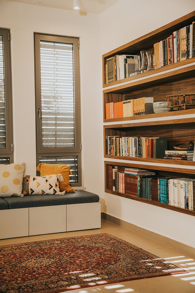 מדפי ספרים שקועים מובנים ומושב קריאה מרופד