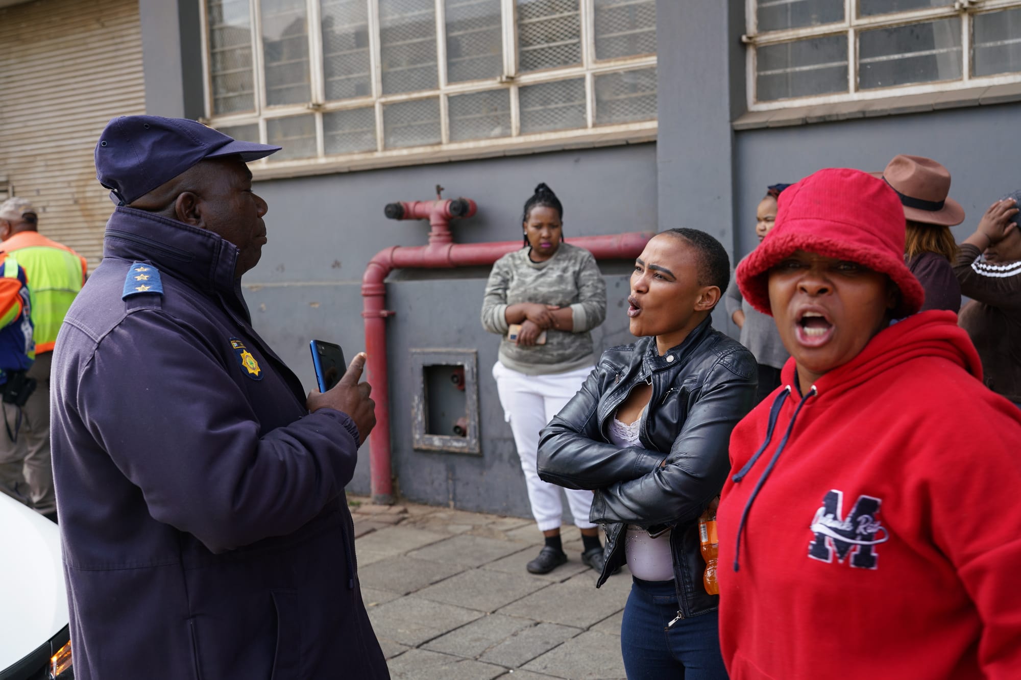 Women argue with a police officer after their building was disconnected from the electricity