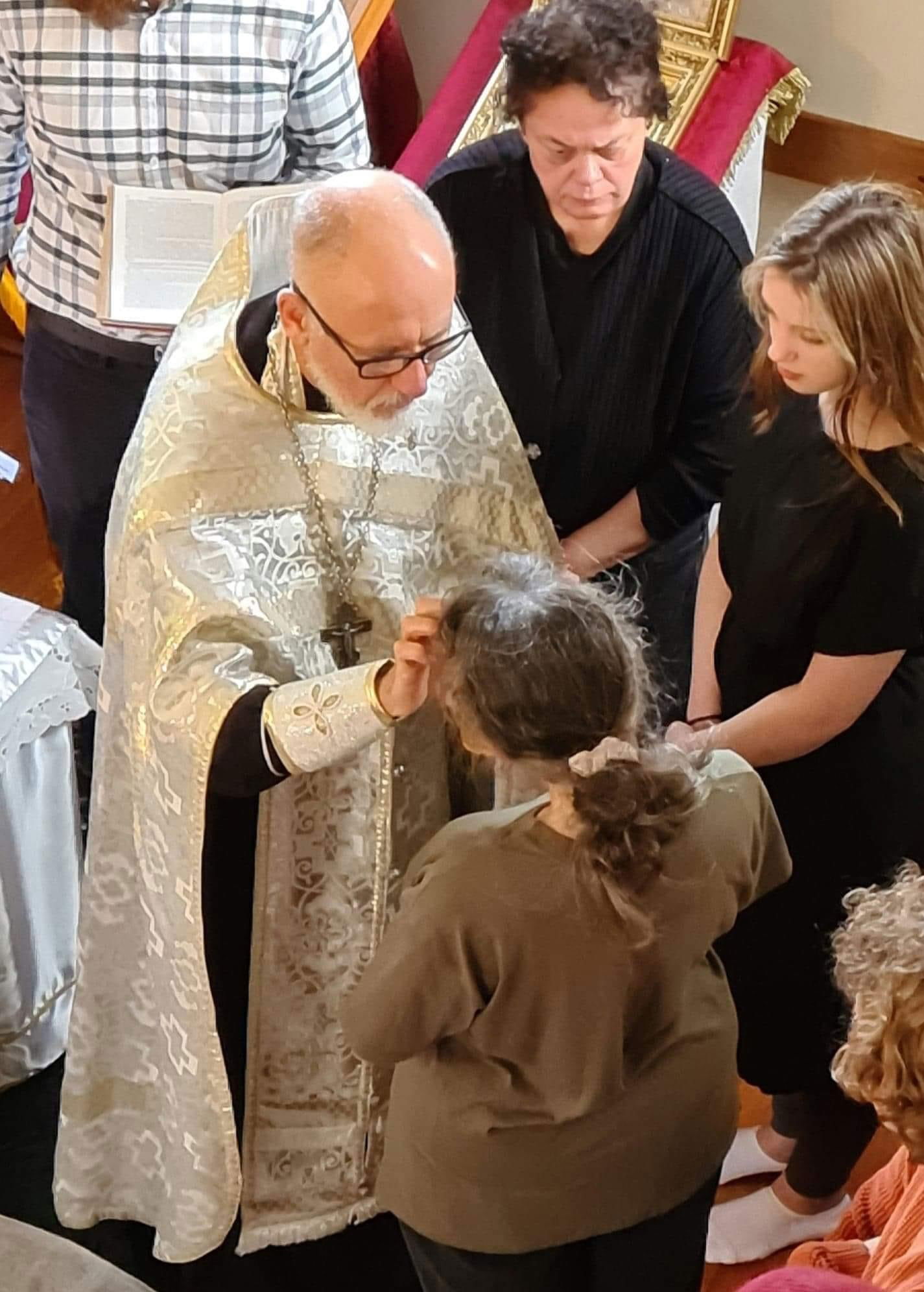 A convert being Anointed during Chrismation which is part of the Baptismal Service.