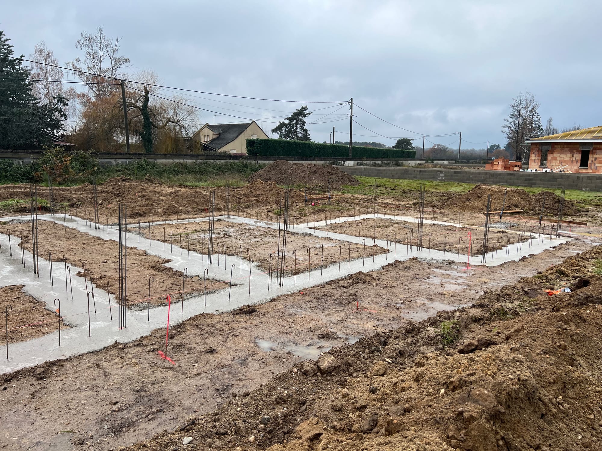 Les premières étapes de travaux de maçonnerie - le coulage des fondations en  béton dosé 300kg/m3