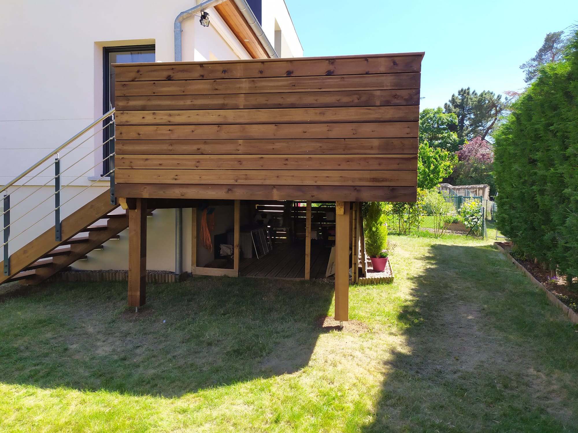 Terrasse en pin autoclave marron, bac à plantes et escalier bois