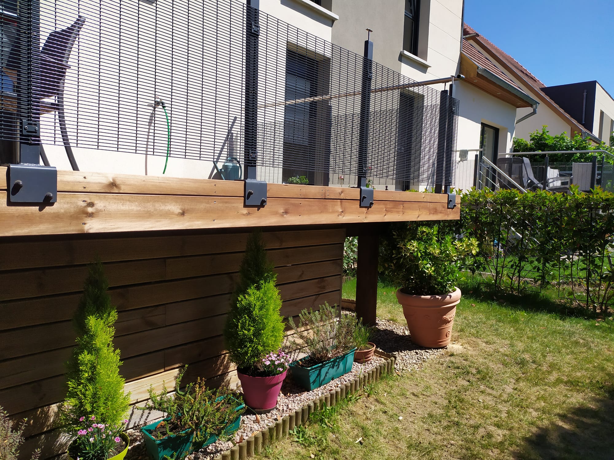 Terrasse en pin autoclave marron, bac à plantes et escalier bois
