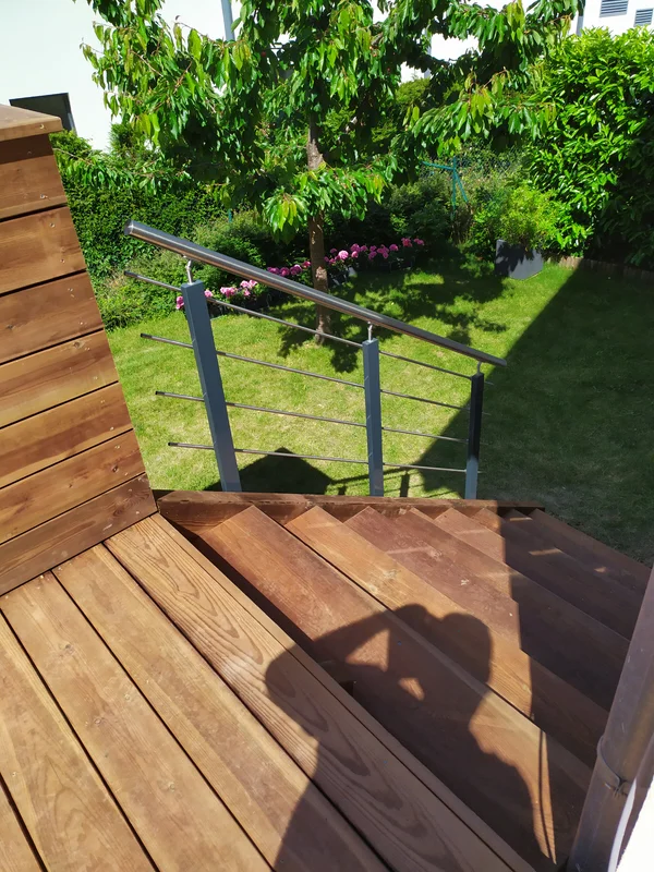 Terrasse en pin autoclave marron, bac à plantes et escalier bois