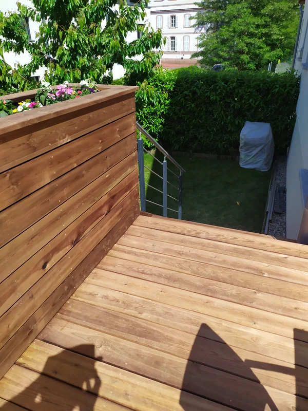 Terrasse en pin autoclave marron, bac à plantes et escalier bois