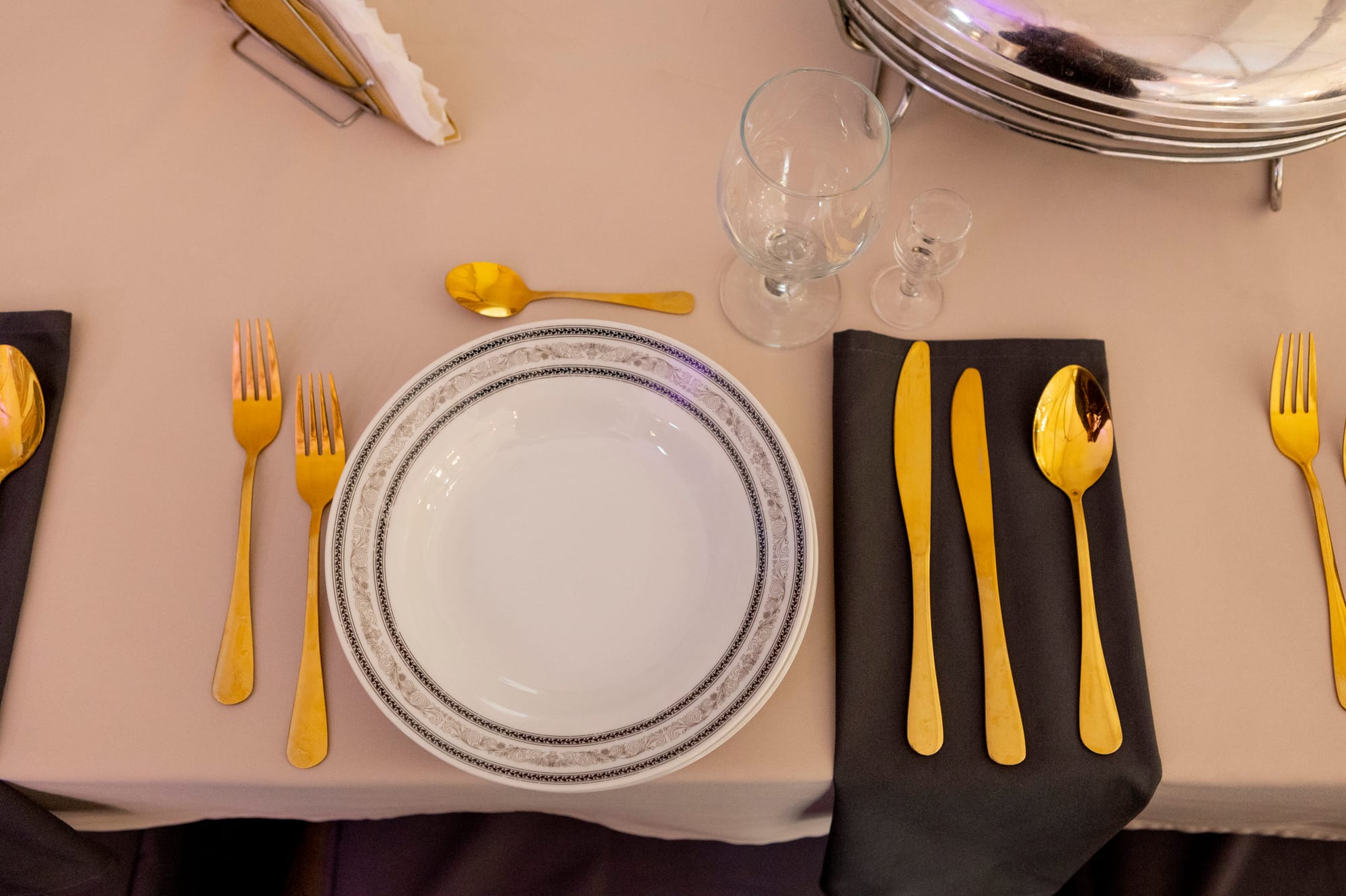 Złote sztućce i okrągłe talerze.
