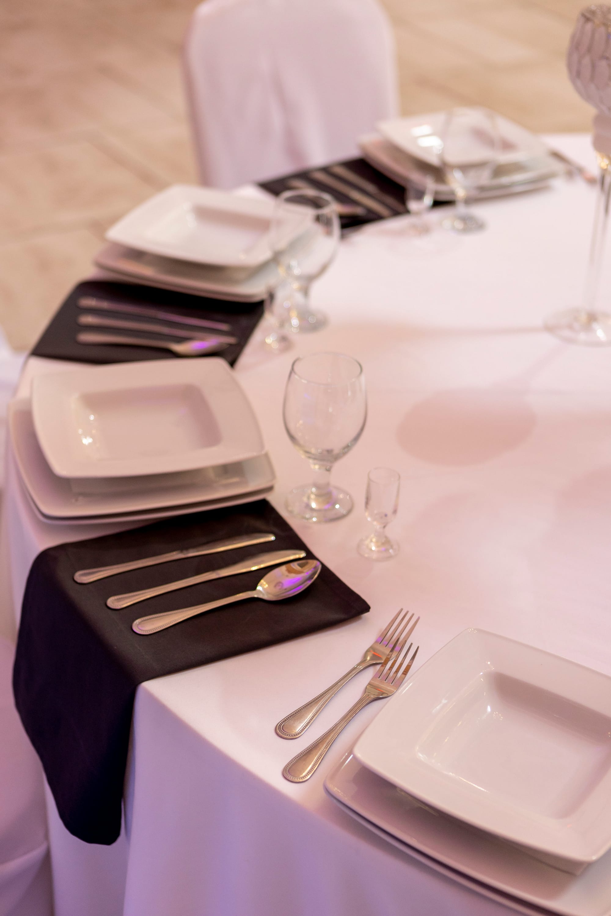 Srebrne sztućce i kwadratowe talerze.