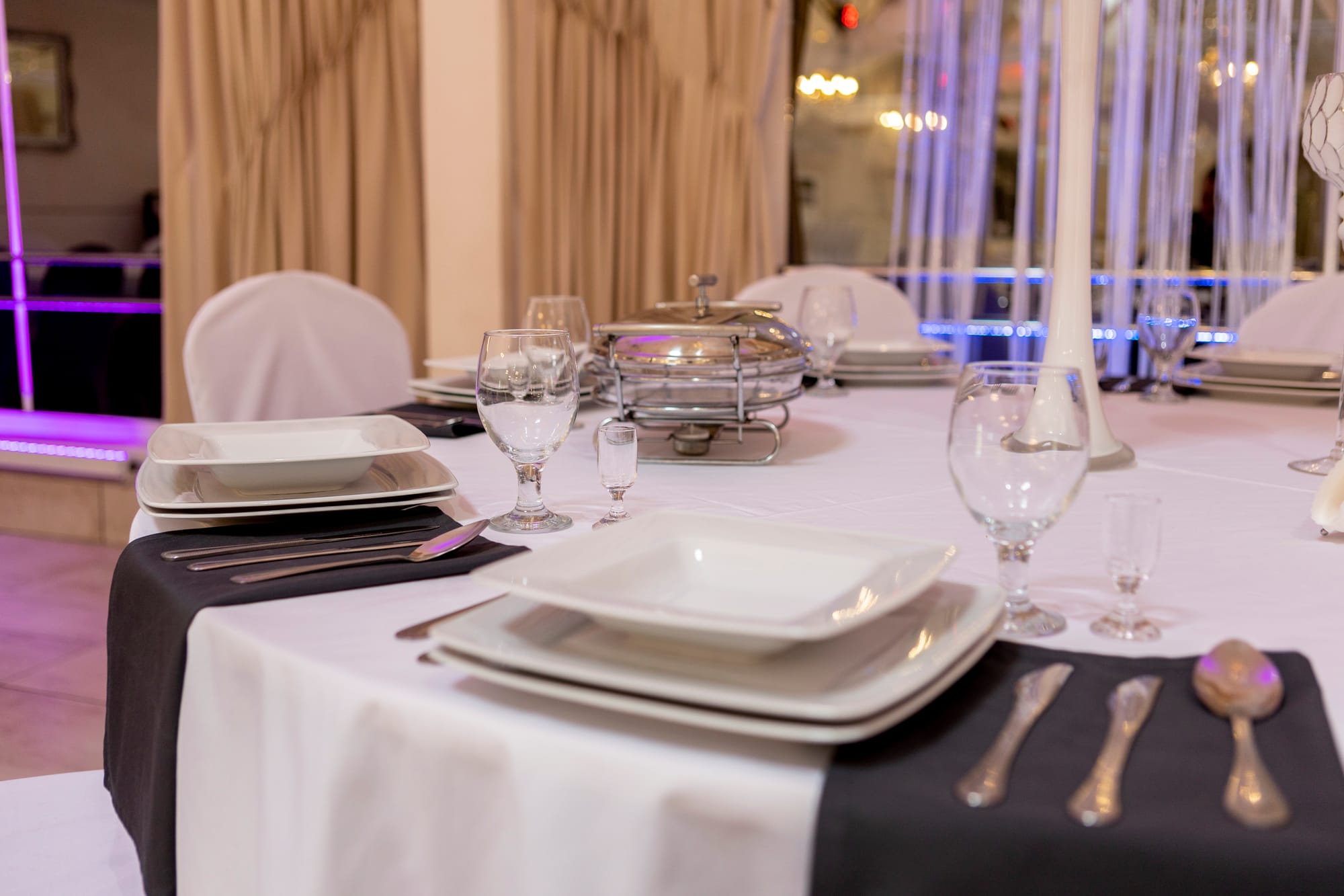 Srebrne sztućce i kwadratowe talerze.