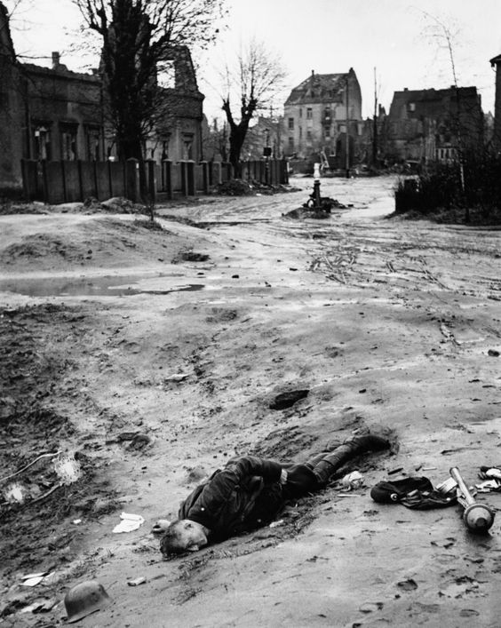 World War II 1945 A dead German soldier lies next to a grenade in a town in north-west Europe during