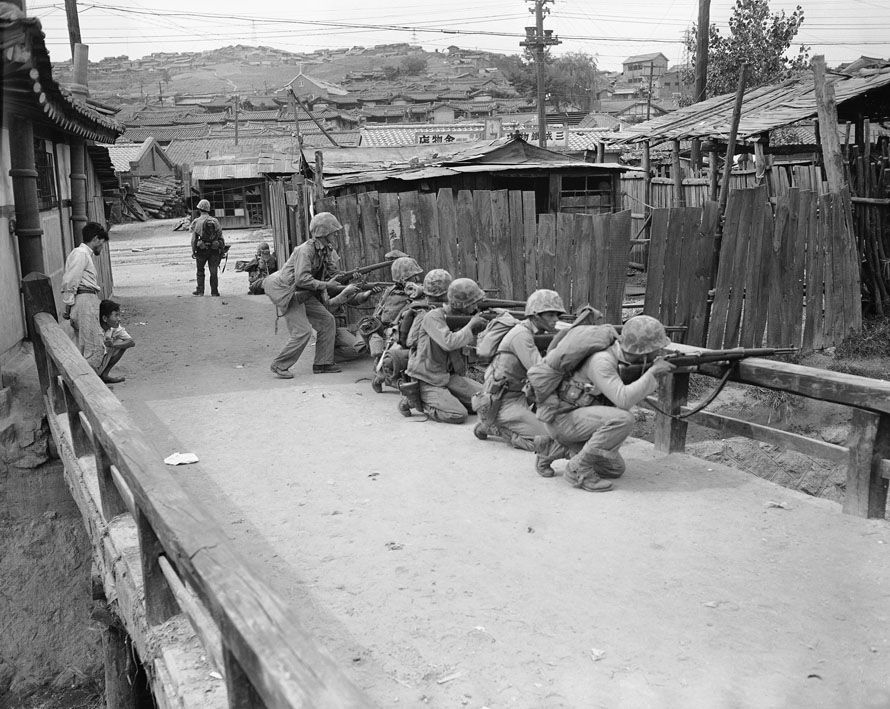Korean War 1950. American soldiers take cover from North Korean snipers