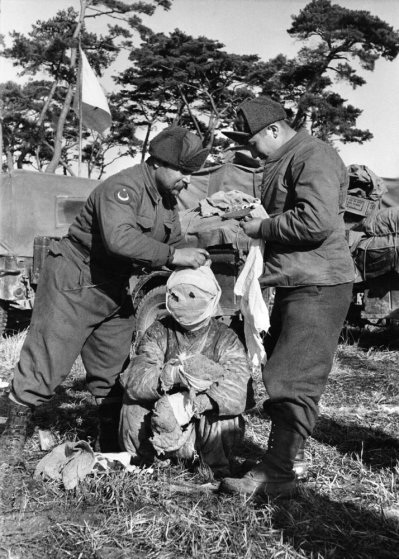 Korean War Turkish soldiers attend to a wounded prisoner, Korea 1951