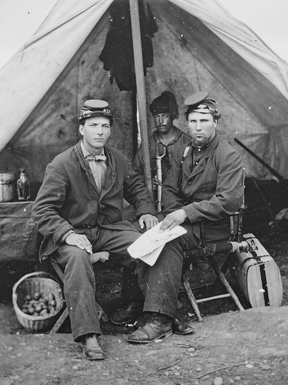 Civil War Union Zouaves of the 4th Michigan Volunteer Infantry Regiment posing in a tent in a camp during the Civil War