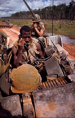 Vietnam War United States 25th Division troops ride on top of M113 Armored Personnel Carriers in Ambush Alley, on the Tay Ninh-Dau Tieng road, 1968