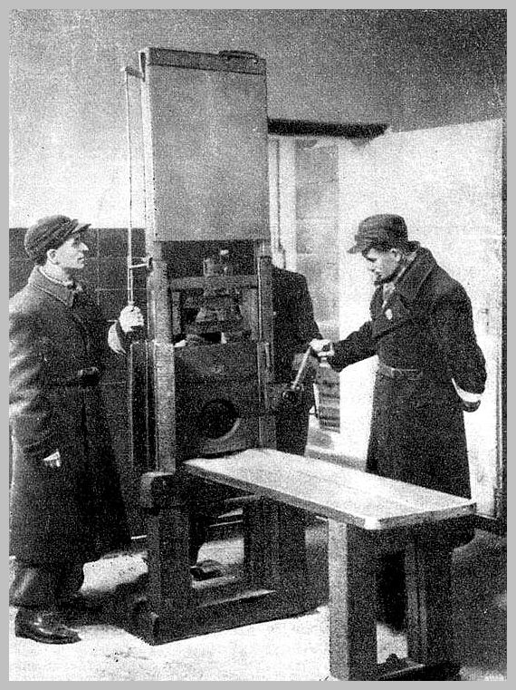 World War 2 Russians examine the guillotine at the death cell in Poznan, Poland. March 1945