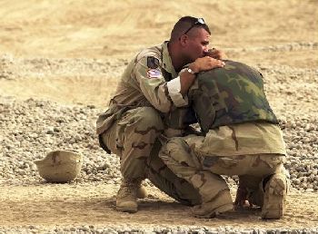 Iraq war, a U.S. military police officer is comforted after seeing three Iraqi children who were brought to the base after being seriously injured