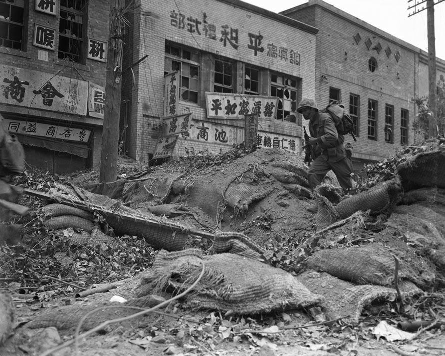 Korean War  September, 1950. An US soldier clambers over a barrier in war torn Seoul. The North Koreans had held it for three months.