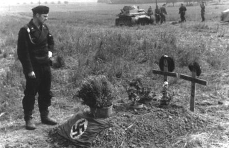 World War 2 German soldier looks at grave of fallen comrade
