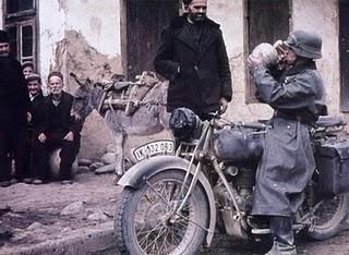 World War 2 A German motorcyclist drinks from a jug that have shown him the people of a Hungarian village.