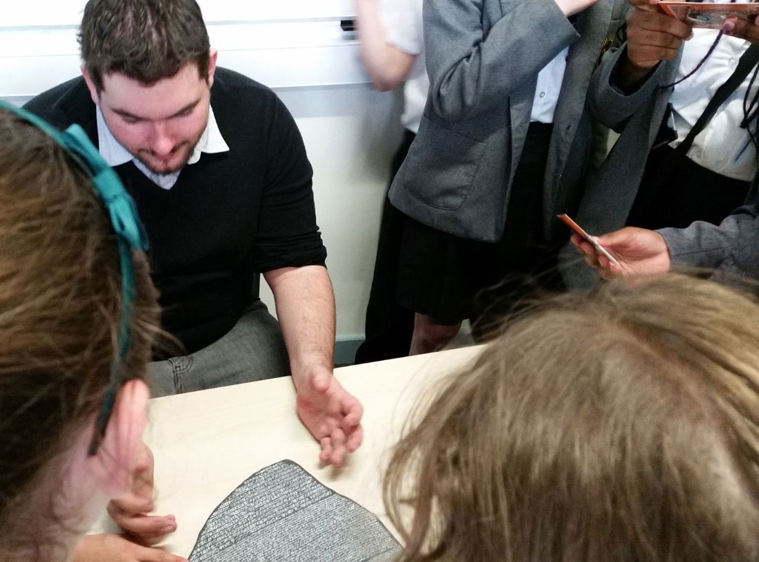 A group of students listen to me during an "Open Day" at the University of Liverpool for the subject of Classics and Ancient History. Here, I am using regalia to explain the use of ancient languages on artefac replicas, such as the Rosetta Stone (pictured).