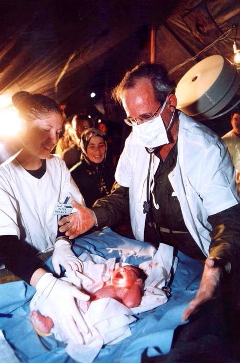 פרופ' אנגלהרט מילד תינוק בבית-החולים הצבאי שנשלח לטורקיה בזמן רעידת האדמה שאירעה ב - 1999 | Professor Englheart delivering a baby at the Israeli field hospital in Turkey. Photo taken during the 1999 earthquake
