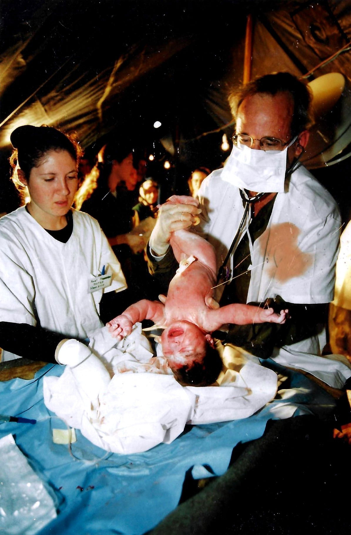 פרופ' אנגלהרט מילד תינוק בבית-החולים הצבאי שנשלח לטורקיה בזמן רעידת האדמה שאירעה ב - 1999 | Professor Englheart delivering a baby at the Israeli field hospital in Turkey. Photo taken during the 1999 earthquake