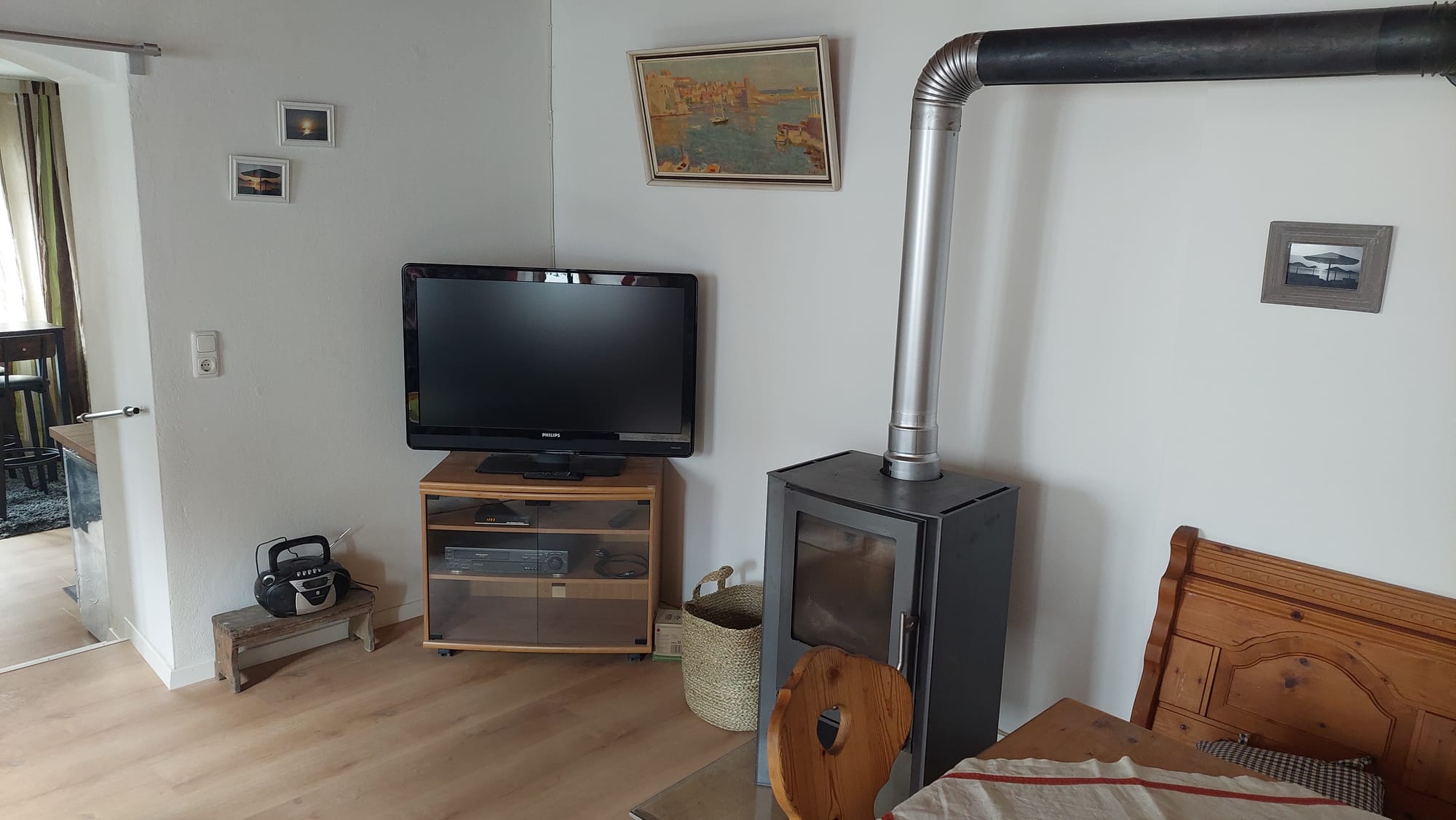 Wohnzimmer mit Holzofen und Fernseher